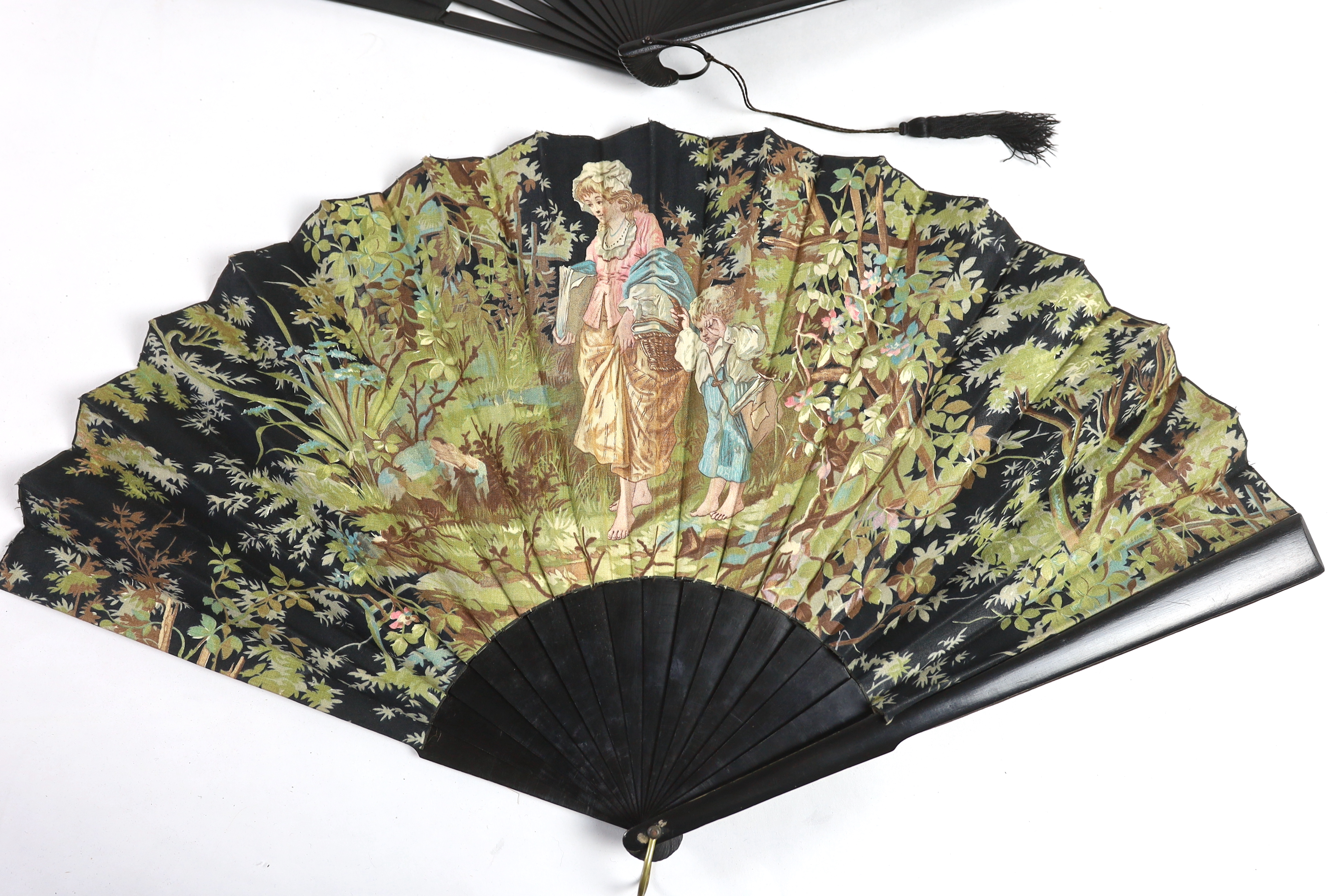 Two early 20th century ebony fans, one cotton leaf, the other hand painted pansies on a fine a silk leaf